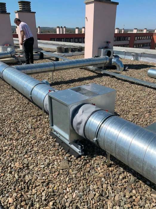 Technicien en toiture-terrasse inspectant une installation CVC